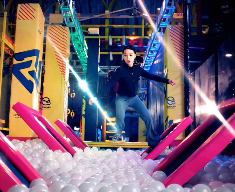 A kid leaping across the Warrior Course at Urban Air.