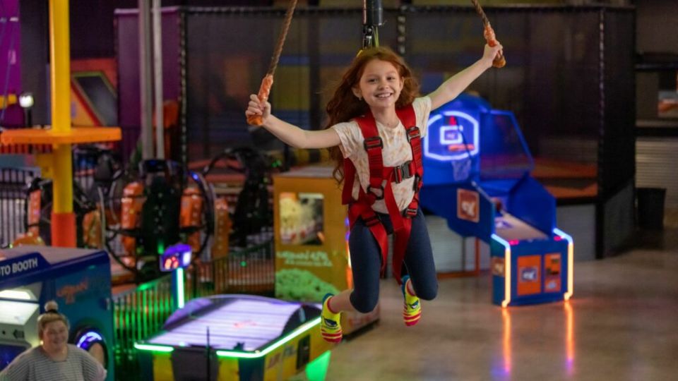 Grade School Child enjoys Urban Air's Sky Rider indoor zipline. 