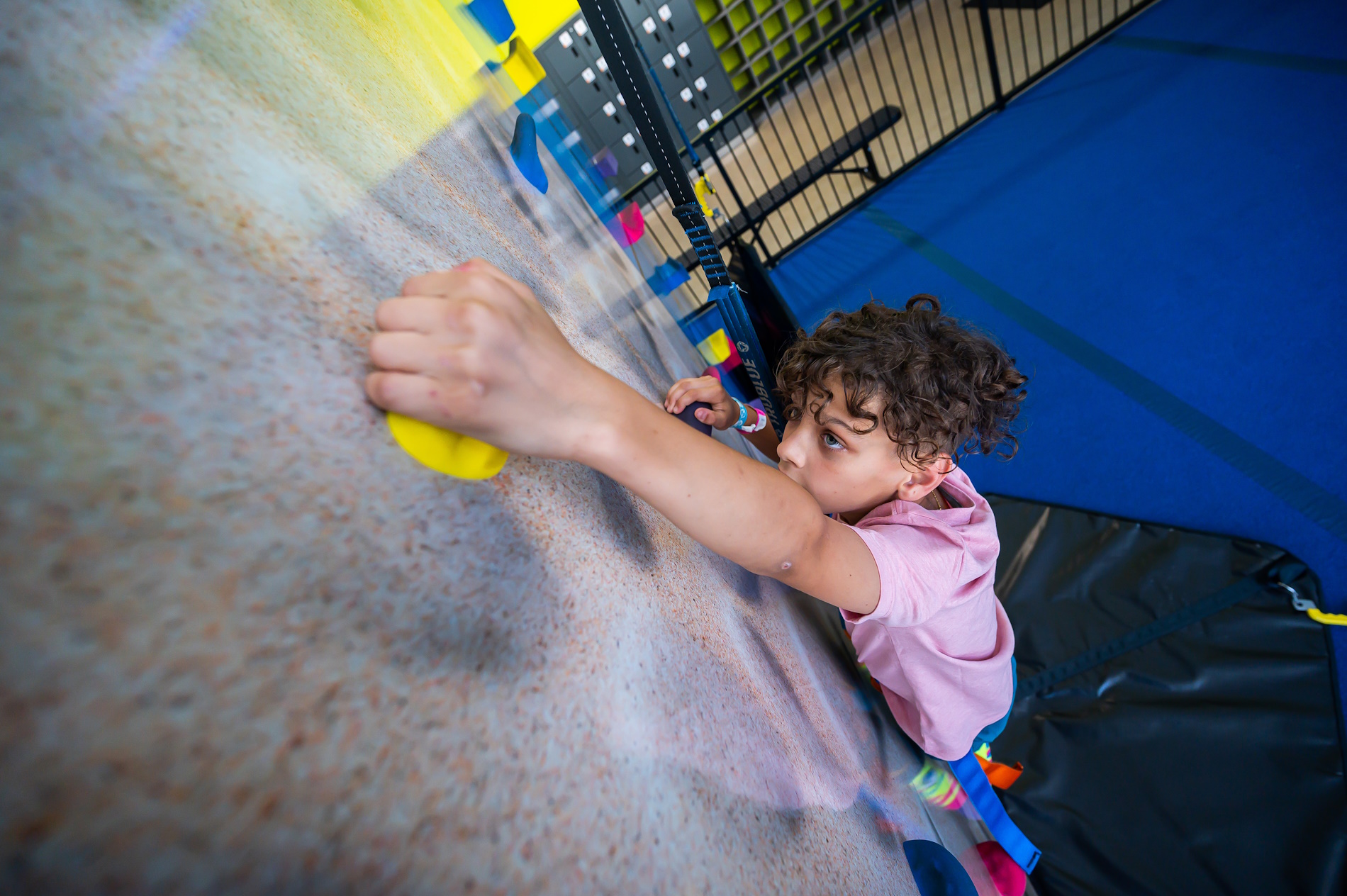 child on a rock climbing course at urban air