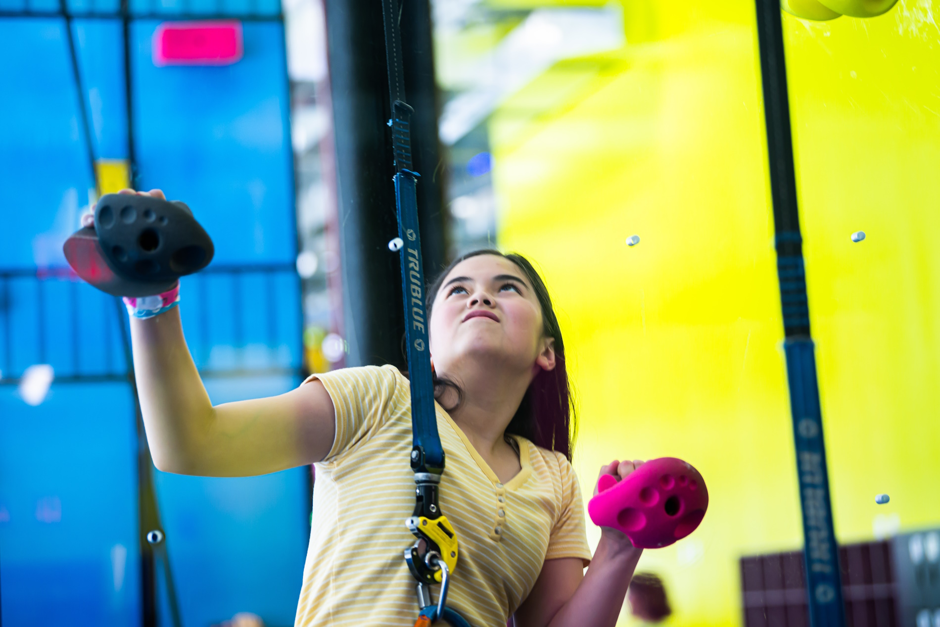 girl challenging herself on a rock climbing wall