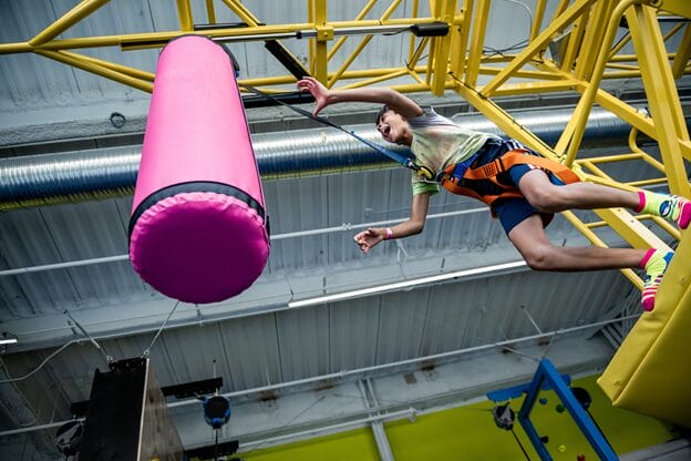 A young boy is with punching bag in the urban air park
