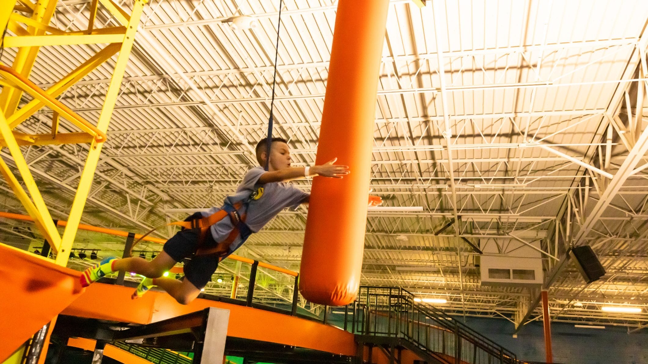 A young kid is playing with punching bag at urban air