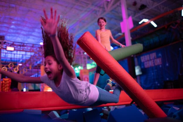 girl falling off battle beam at urban air