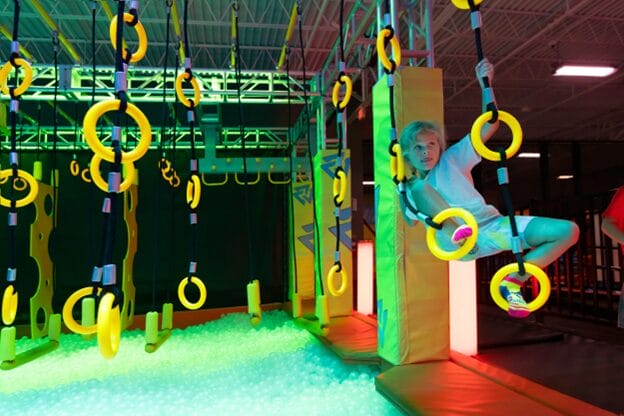 child swinging on gymnastics rings