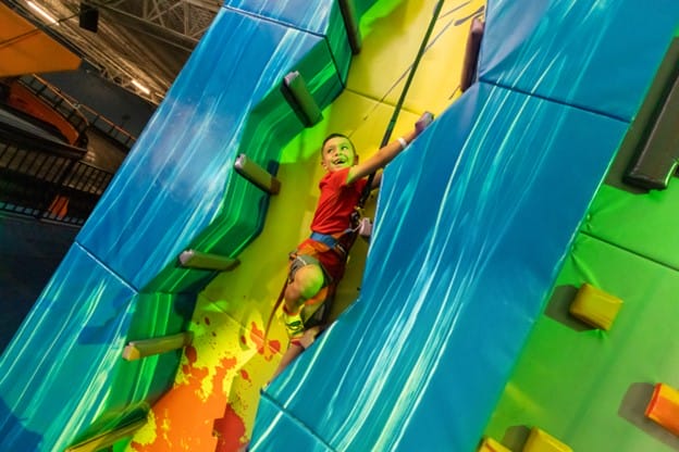 boy climbing a wall at urban air